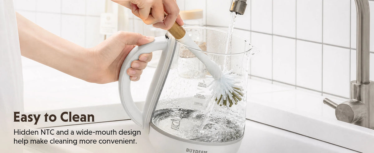 A person holds a white electric kettle while running water, with a cleaning brush inside. Text on the left reads 'Easy to Clean' and describes the hidden NTC and wide-mouth design.